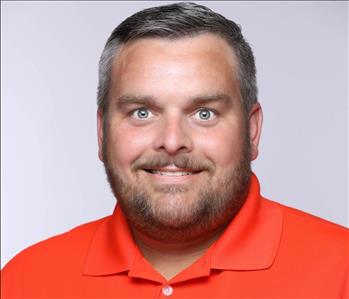 White Male, Smiling, Brown Hair, with a orange shirt and light purple background