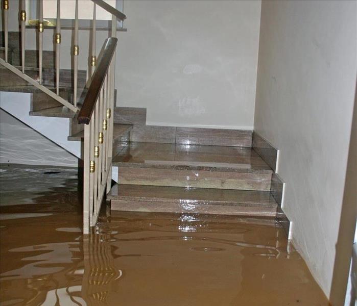 Flooded waters reaching stairs in the inside if a house